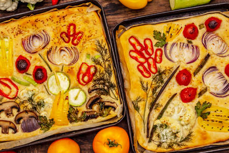 Colorful Garden Focaccia. Fresh ripe vegetables, olive oil, greens. Traditional Italian bakery. Old wooden boards backgroundの写真素材