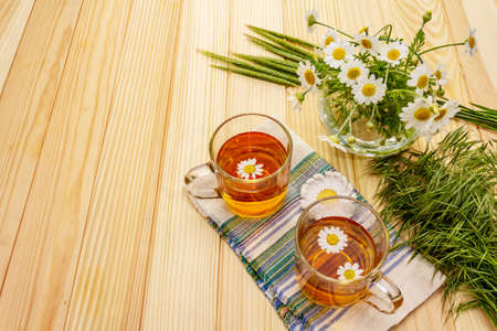 Chamomile tea. Fresh flowers, summer hot drink concept. Alternative medicine, lifestyle.Wooden boards background, copy spaceの写真素材