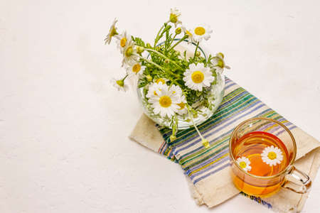 Chamomile tea. Fresh flowers, summer hot drink concept. Alternative medicine, lifestyle. White putty background, top viewの写真素材