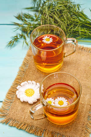 Chamomile tea. Fresh flowers, summer hot drink concept. Alternative medicine, lifestyle. Trendy turquoise wooden boards background, copy spaceの写真素材