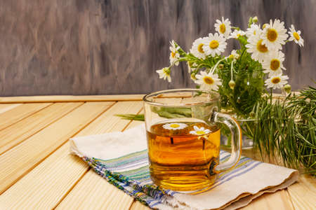 Chamomile tea. Fresh flowers, summer hot drink concept. Alternative medicine, lifestyle.Wooden boards background, copy spaceの写真素材