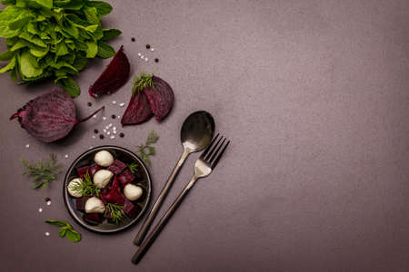 Culinary background. Cooking food concept. Healthy salad with baked beetroot, baby mozzarella, fresh greens. Trendy black stone concrete backdrop, top viewの写真素材