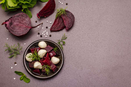 Culinary background. Cooking food concept. Healthy salad with baked beetroot, baby mozzarella, fresh greens. Trendy black stone concrete backdrop, top viewの写真素材