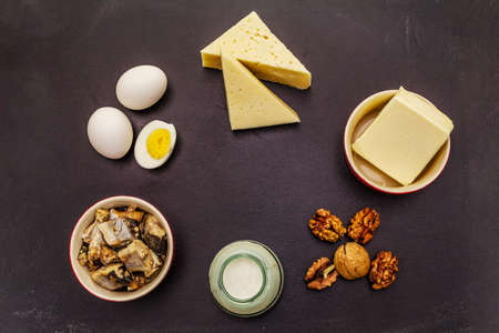 Foods containing vitamin D. Cheese, eggs, butter, nuts, milk, sardine. Black chalk board backgroundの写真素材