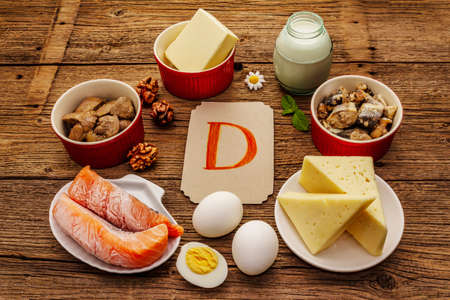 Foods containing vitamin D. Cheese, eggs, butter, nuts, milk, sardine, salmon, liver. Old wooden boards backgroundの写真素材