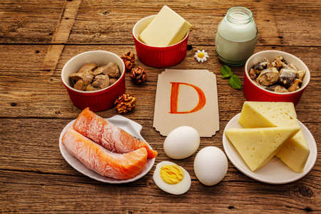 Foods containing vitamin D. Cheese, eggs, butter, nuts, milk, sardine, salmon, liver. Old wooden boards backgroundの写真素材