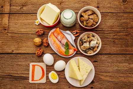 Foods containing vitamin D. Cheese, eggs, butter, nuts, milk, sardine, salmon, liver. Old wooden boards backgroundの写真素材