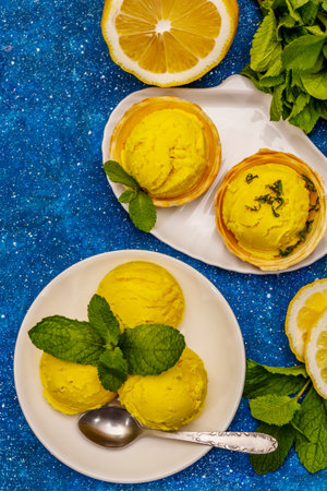 Lemon ice cream with mint. Refreshing summer dessert, ripe fruit, fragrant leaves. Navy blue...