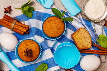 Homemade cupcakes with cinnamon, star anise and fresh mint. Bakery concept, set of ingredients for cooking. Stone concrete background, top viewの写真素材