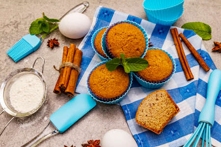 Homemade cupcakes with cinnamon, star anise and fresh mint. Bakery concept, set of ingredients for cooking. Stone concrete background, close upの写真素材