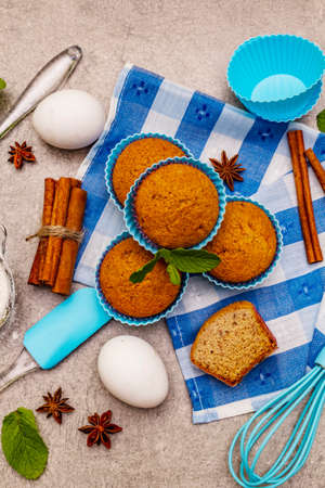 Homemade cupcakes with cinnamon, star anise and fresh mint. Bakery concept, set of ingredients for cooking. Stone concrete background, top viewの写真素材