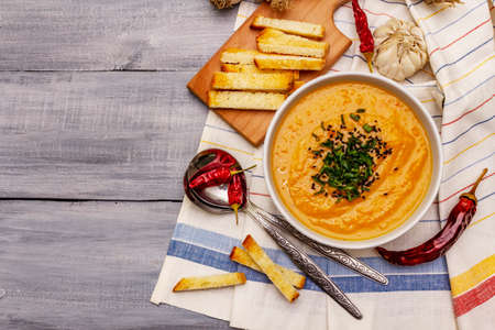 Vegetable cream soup. Healthy vegan (vegetarian) nutrition concept. Garlic, croutons, spices, aromatic seasonings. Wooden boards background, top viewの写真素材
