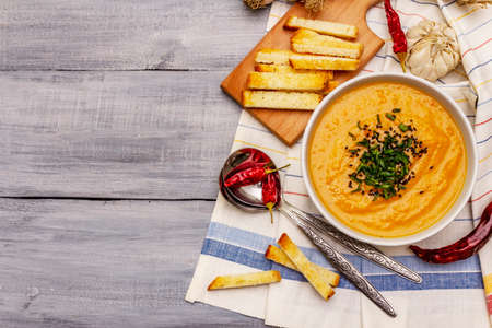 Vegetable cream soup. Healthy vegan (vegetarian) nutrition concept. Garlic, croutons, spices, aromatic seasonings. Wooden boards background, top viewの写真素材