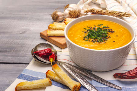 Vegetable cream soup. Healthy vegan (vegetarian) nutrition concept. Garlic, croutons, spices, aromatic seasonings. Wooden boards background, copy spaceの写真素材