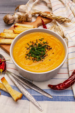 Vegetable cream soup. Healthy vegan (vegetarian) nutrition concept. Garlic, croutons, spices, aromatic seasonings. Wooden boards background, close upの写真素材