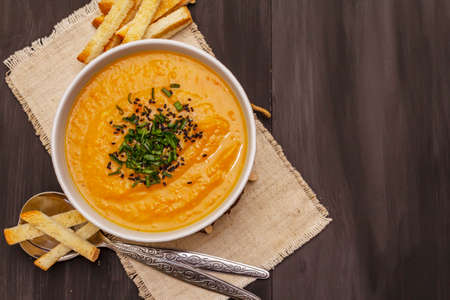 Vegetable cream soup. Healthy vegan (vegetarian) nutrition concept. Garlic, croutons, spices, aromatic seasonings. Trendy black wooden boards background, top viewの写真素材