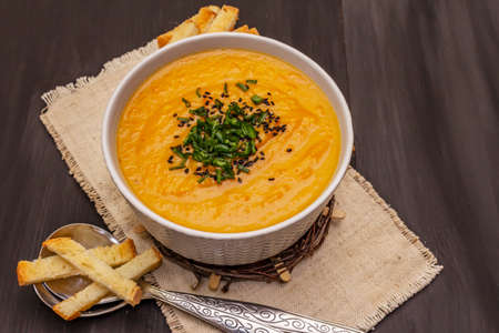 Vegetable cream soup. Healthy vegan (vegetarian) nutrition concept. Garlic, croutons, spices, aromatic seasonings. Trendy black wooden boards background, copy spaceの写真素材