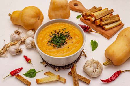 Vegetable cream soup. Healthy vegan (vegetarian) nutrition concept. Garlic, croutons, spices, aromatic seasonings. White putty background, close upの写真素材
