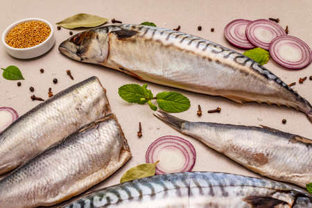 Assorted pickled whole fish. Norwegian herring "Matthias", mackerel spicy salting. Spices, Dijon mustard, onions. Stone concrete backgroundの写真素材