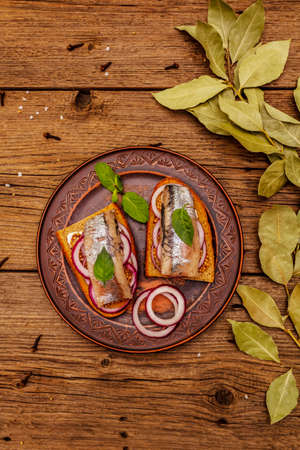 Traditional Norwegian or Danish smorrebrod. Herring sandwich, healthy eating concept. Wooden background, top viewの写真素材