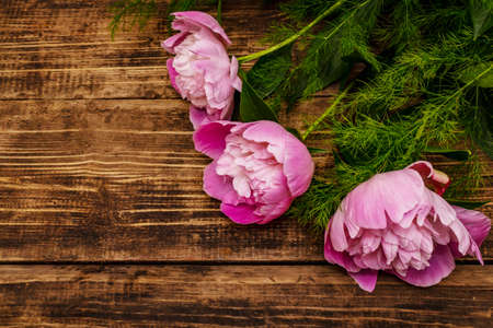 Fragrant pink peonies. Beautiful bouquet on vintage wooden background. Romantic mood concept, copy spaceの写真素材