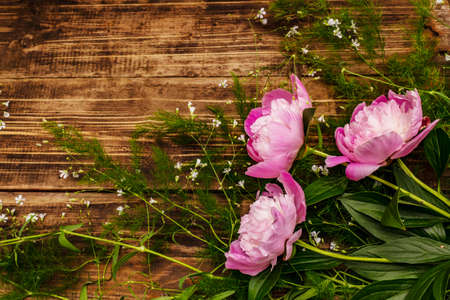 Fragrant pink peonies. Beautiful bouquet on vintage wooden background. Romantic mood concept, top viewの写真素材