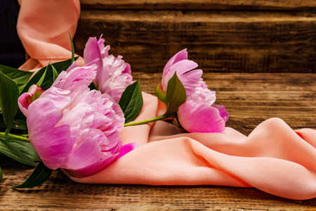 Fragrant pink peonies. Beautiful bouquet on vintage wooden background. Romantic mood concept, copy spaceの写真素材
