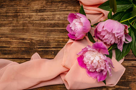 Fragrant pink peonies. Beautiful bouquet on vintage wooden background. Romantic mood concept, top viewの写真素材