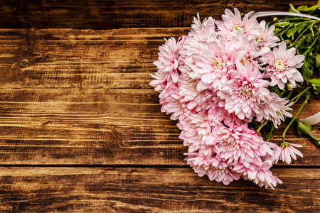 Bouquet of gently pink chrysanthemums. Beautiful gift on vintage wooden background. Romantic mood concept, top viewの写真素材
