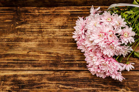 Bouquet of gently pink chrysanthemums. Beautiful gift on vintage wooden background. Romantic mood concept, top viewの写真素材