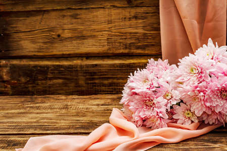 Bouquet of gently pink chrysanthemums. Beautiful gift on vintage wooden background. Romantic mood concept, copy spaceの写真素材