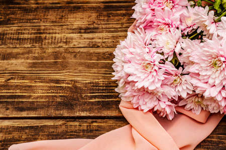 Bouquet of gently pink chrysanthemums. Beautiful gift on vintage wooden background. Romantic mood concept, top viewの写真素材