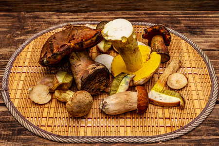 Fresh forest mushrooms. Assorted gourmet porcini and boletus. Old wood plank background, close upの写真素材