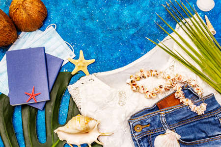 Travel and vacation coronavirus concept. Summer 2020 background with medical mask, passports, beachwear, marine symbols and jewelry. Nautical backgroundの写真素材