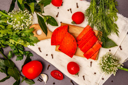 Dutch gouda pesto red cheese. Ripe tomatoes, fresh herbs, fragrant spices. Black stone concrete background, top viewの写真素材