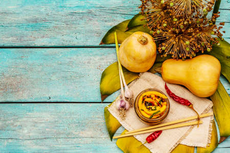 Hobak pumpkin kimchi. Korean traditional savory food. Spicy marinated pieces, fragrant spices, fresh vegetables. Trendy turquoise wooden boards background, top viewの写真素材