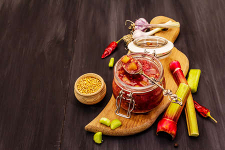 Chutney from rhubarb. Set of ingredients and spices for cooking. Black wooden background, copy spaceの写真素材