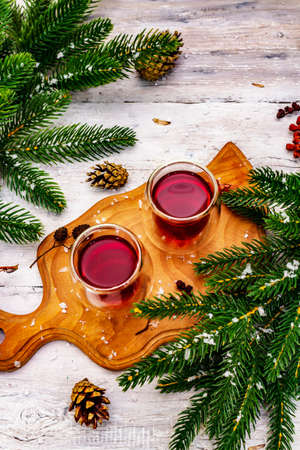 Festive berries liqueur or tincture in double-walled glasses. Ingredient for preparation alcohol cocktail. New Year or Christmas design, white wooden boards background, top viewの写真素材