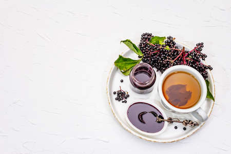 Elderberry jam, syrup, confiture and hot tea. Ripe berries, sweet and healthy dessert. Alternative...
