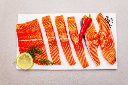 Raw Norwegian Trout Fillet. A piece of fresh fish, lemon, dill, hot pepper, salt. Sushi grade, stone...