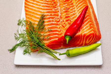 Raw Norwegian Trout Fillet. A piece of fresh fish, lemon, dill, hot pepper, salt. Sushi grade, stone...