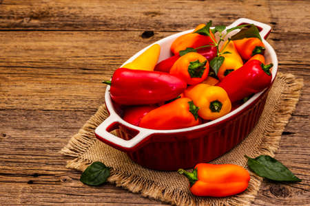 Assorted ripe multi-colored baby peppers: red, orange and yellow. Fresh harvest, juicy products for...