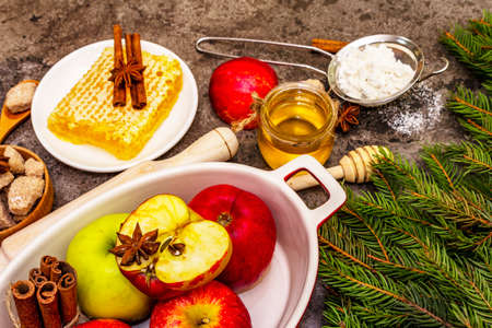 Christmas or New Year apple pie baking concept. Healthy ingredients, evergreen fir-tree branches. Stone concrete backgroundの写真素材