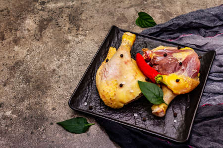 Raw BIO organic chicken legs. Fresh natural meat with vegetables and spices. Stone concrete background, copy spaceの写真素材
