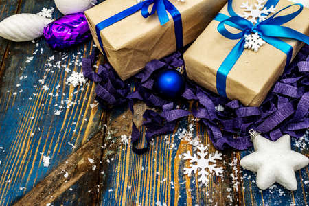 Zero waste Christmas or New Year gift concept. Festive balls and stars, snowflakes and presents. Natural decor for crafting at home. Wooden boards background in blue tones, copy spaceの写真素材