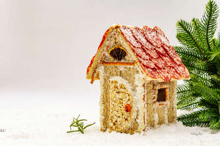 Ð¡harcuterie chalet or The Meat Hut as Christmas newest food trend. New Year Keto gingerbread house with traditional decor and symbols. White snow background, copy spaceの写真素材