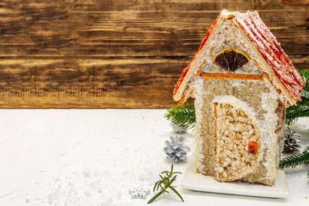 Ð¡harcuterie chalet or The Meat Hut as Christmas newest food trend. New Year Keto gingerbread house with traditional decor and symbols. White putty background, copy spaceの写真素材
