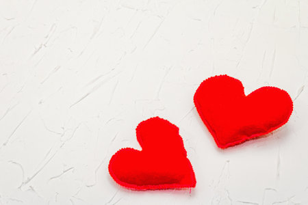 Valentine's Day concept with red hearts. Soft felt hearts and bright decor on white putty background, flat layの写真素材