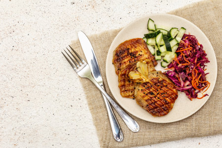 Healthy Paleo food with grilled meat, fresh cucumber, fermented cabbage and carrot. Ketogenic diet concept. Stone concrete background, top viewの写真素材
