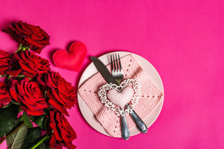 Romantic dinner table. Love concept for Valentine's or mother's day, wedding cutlery. Bouquet of fresh burgundy roses, handmade crochet napkinの写真素材